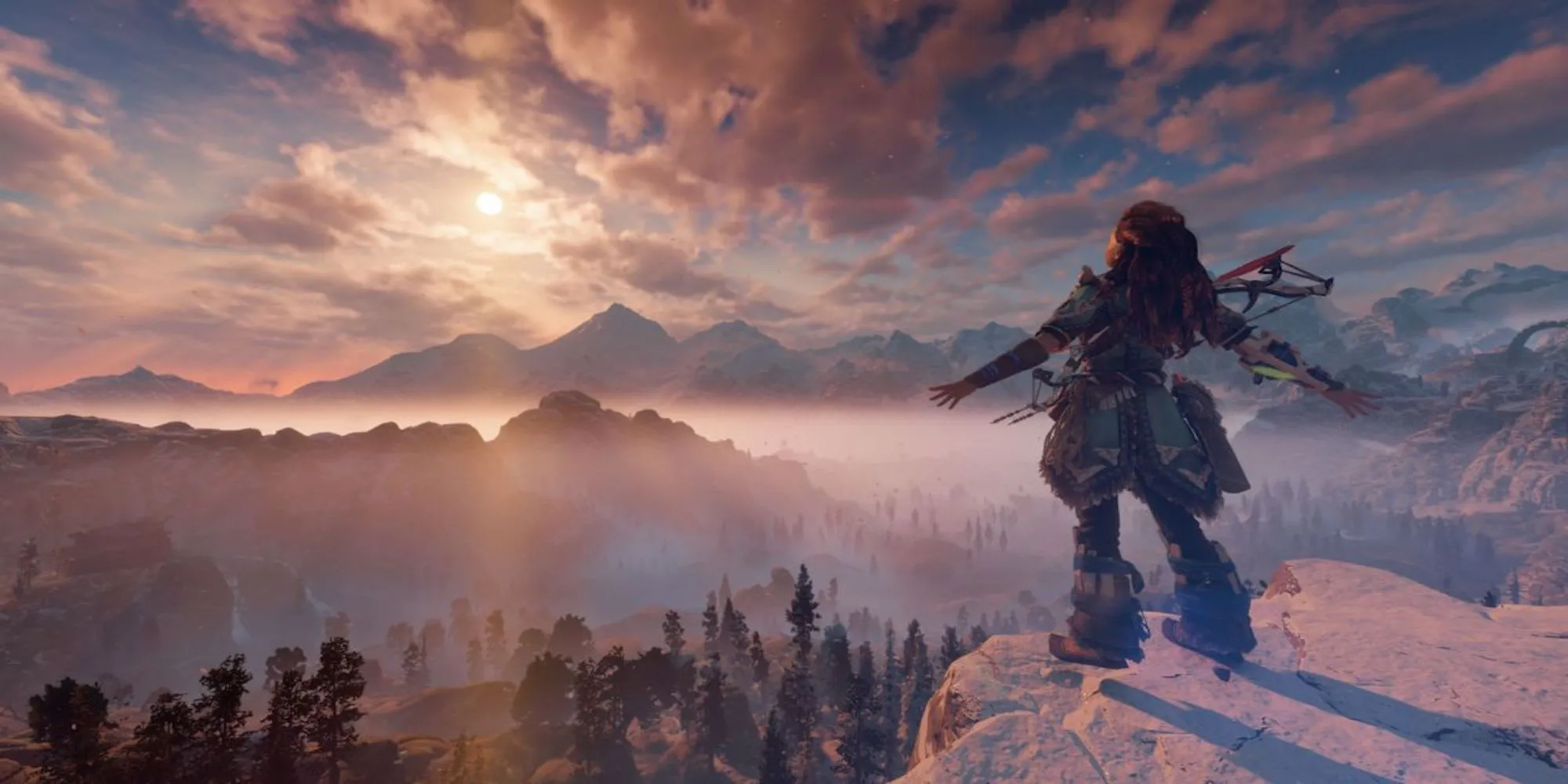 Aloy của Horizon Zero Dawn đứng trên mỏm đá, phóng tầm mắt ra thế giới hậu tận thế đầy những cỗ máy nguy hiểm.