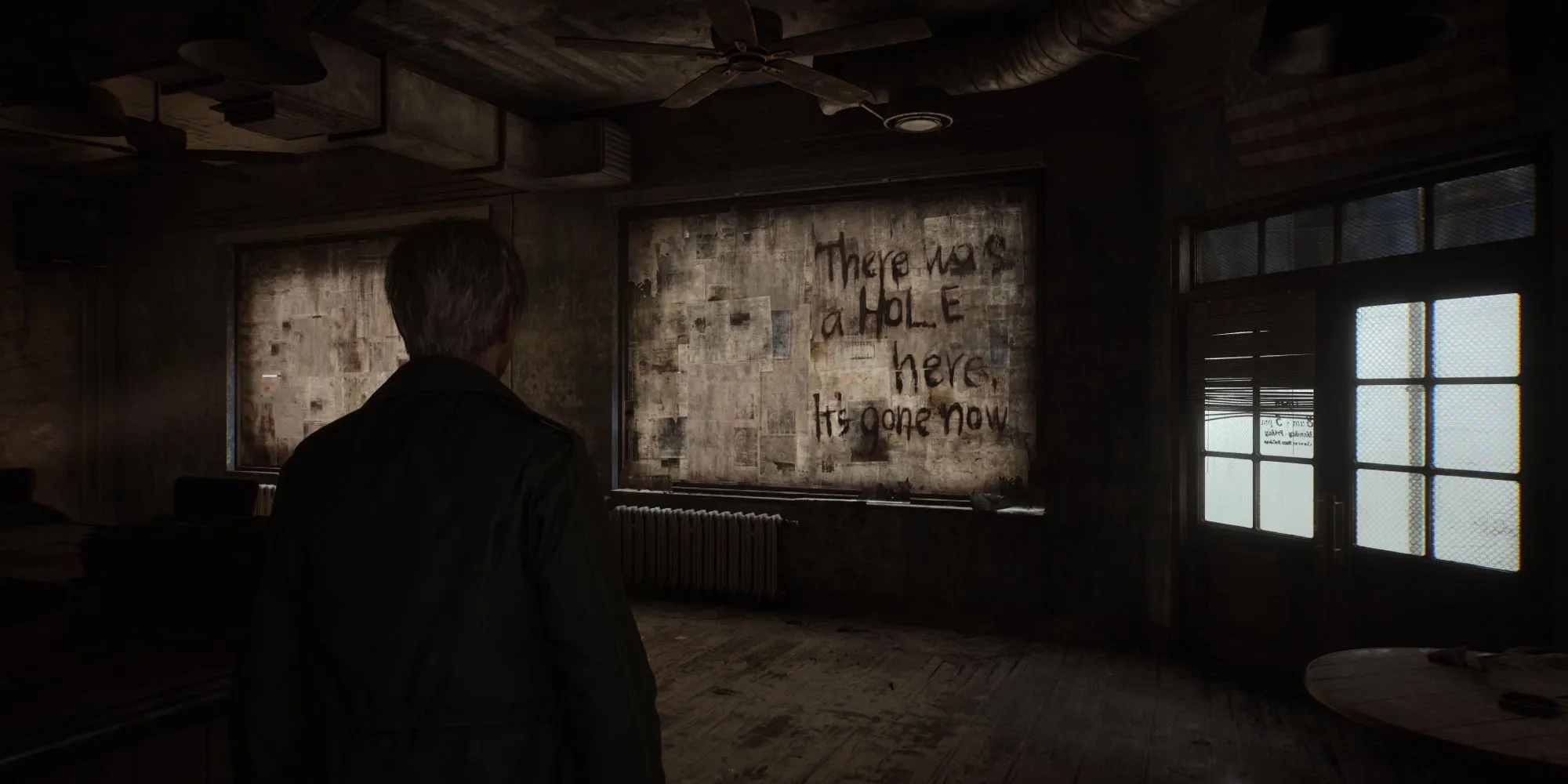 Một cảnh trong Silent Hill 2 Remake cho thấy một thông điệp bí ẩn bên cạnh một cái hố
